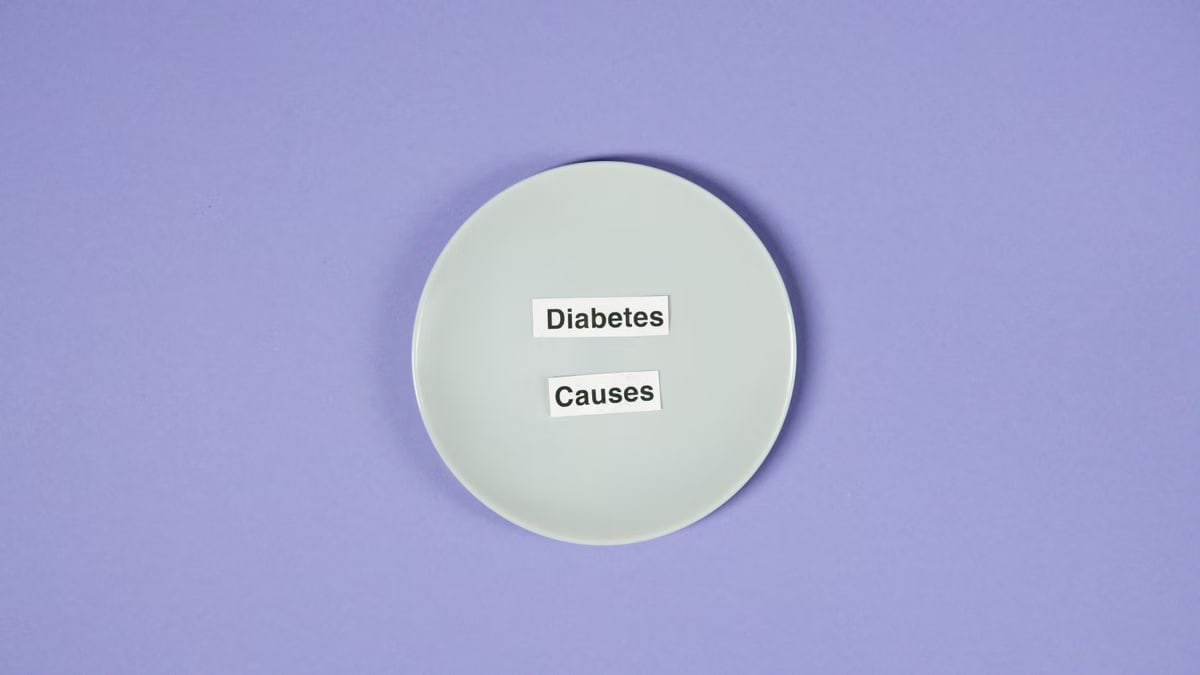 A conceptual photo of a white plate with diabetes causes text on a purple background.